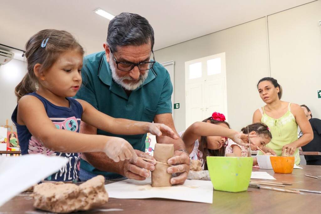 Crianças e pais participando da oficina de modelagem que acontece no Sesc Cultura (Foto: Henrique Kawaminami)