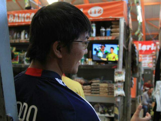 Renan Tsuha levou uma televisão para o trabalho no Mercado Municipal, mas o foco foram as vendas do dia (Foto: Marina Pacheco)