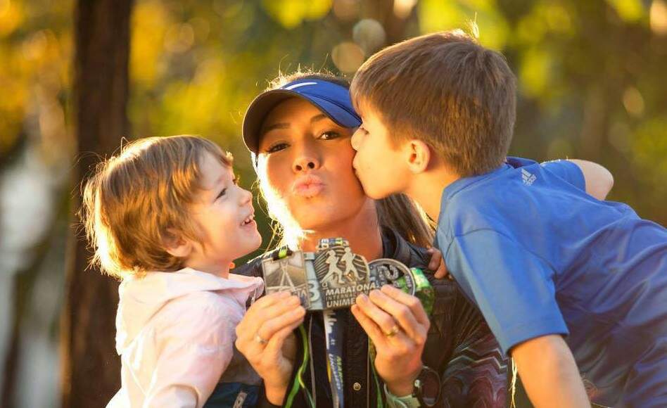 Tatiane comemora sua medalha de maratonista com os filhos João e José, uma rotina há oito anos (Foto: Arquivo pessoal)