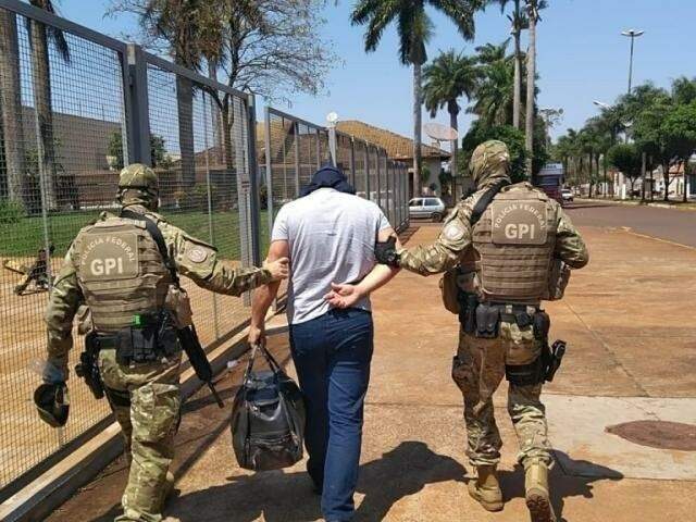 Policiais conduzindo um dos presos na Operação Nepsis, no dia 22 de setembro deste ano (Foto: Adilson Domingos)