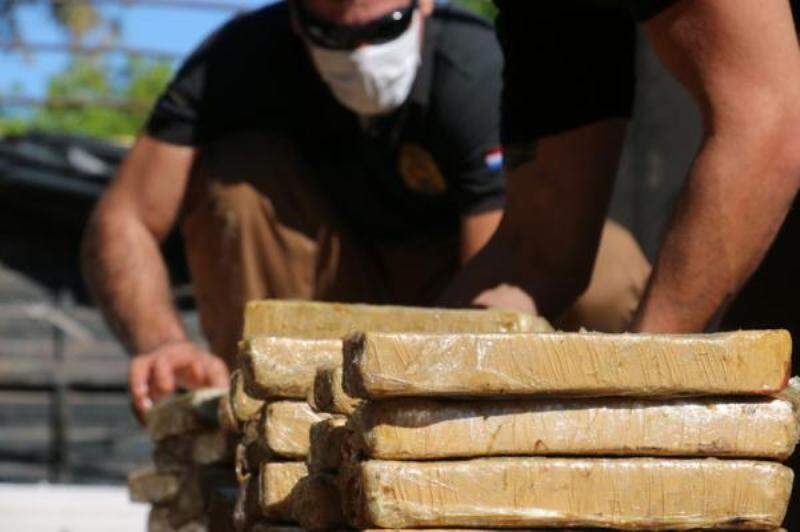 Agente da Senad retira tabletes de maconha de caminhão apreendido perto de Sete Quedas (Foto: Divulgação)