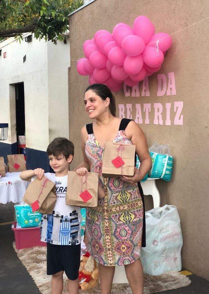 Priscila e o filho, Renan, segurando as sacolinhas com as guloseimas da comemoração. (Foto: Arquivo pessoal)
