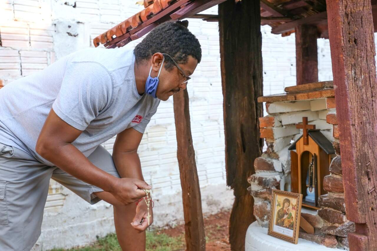 Leomar Soares rezando o terço em frente à capelinha que construiu para Nossa Senhora Aparecida. (Foto: Paulo Francis)