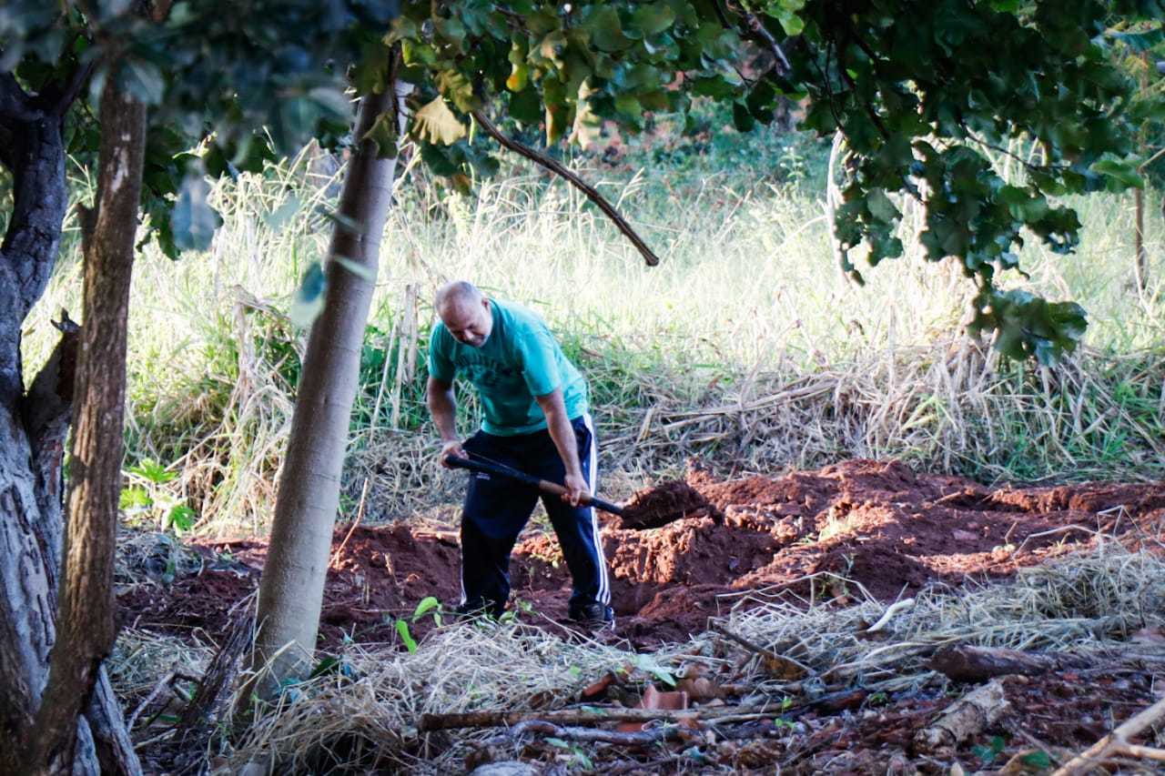 Cleber cavando o local onde uma das v&iacute;timas estava enterrada. (Foto: Henrique Kawaminami)