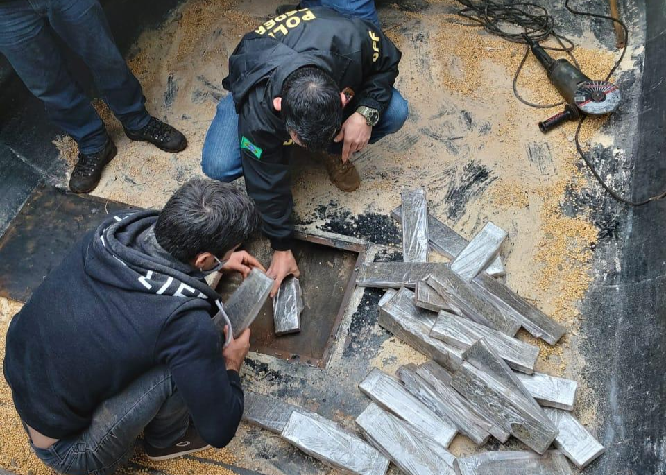 Policiais retirando os tabletes de maconha do assoalho da carreta. (Foto: Polícia Federal)
