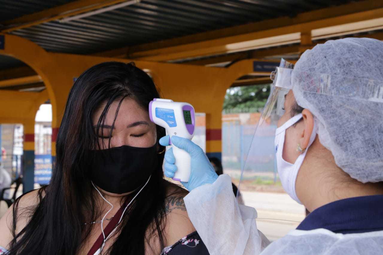 Usuária do transporte coletivo tem temperatura aferida em terminal de Campo Grande. (Foto: Paulo Francis)