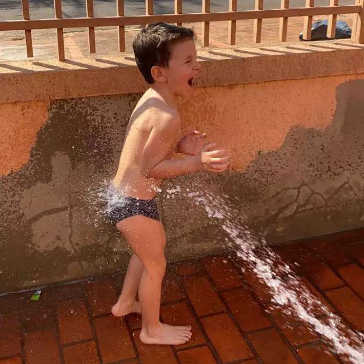 No calorão, criançada se refresca no bom e velho banho de mangueira