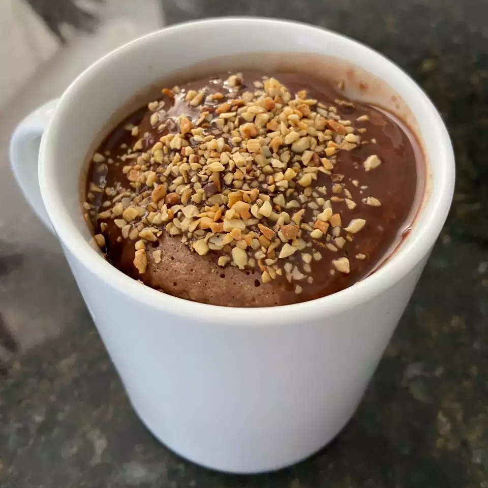 Agora o bolinho está completo! Na caneca, já com calda de chocolate e "decorado" com algumas castanhas picotadinhas para uma crocância especial (Foto: Arquivo Pessoal)