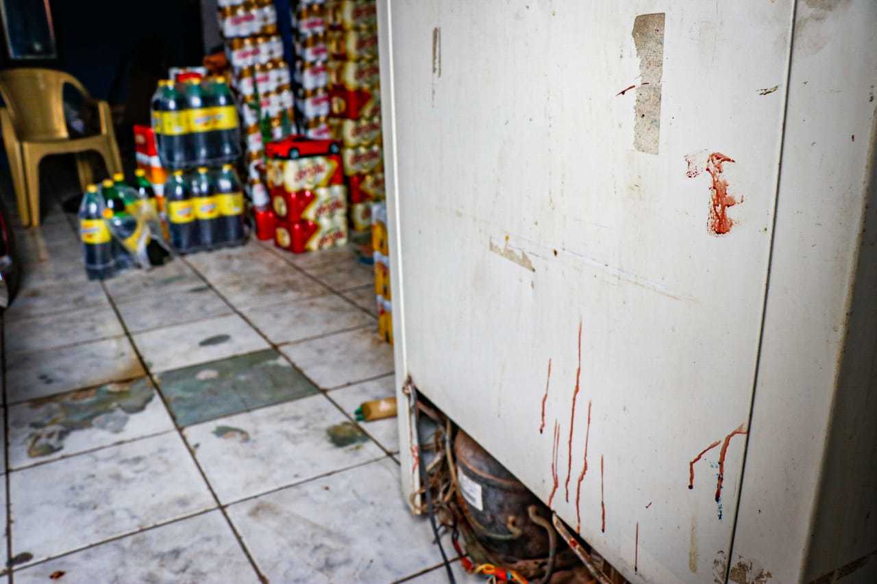 Nesta manhã ainda havia marcas de sangue no portão da conveniência (Foto: Henrique Kawaminami) 