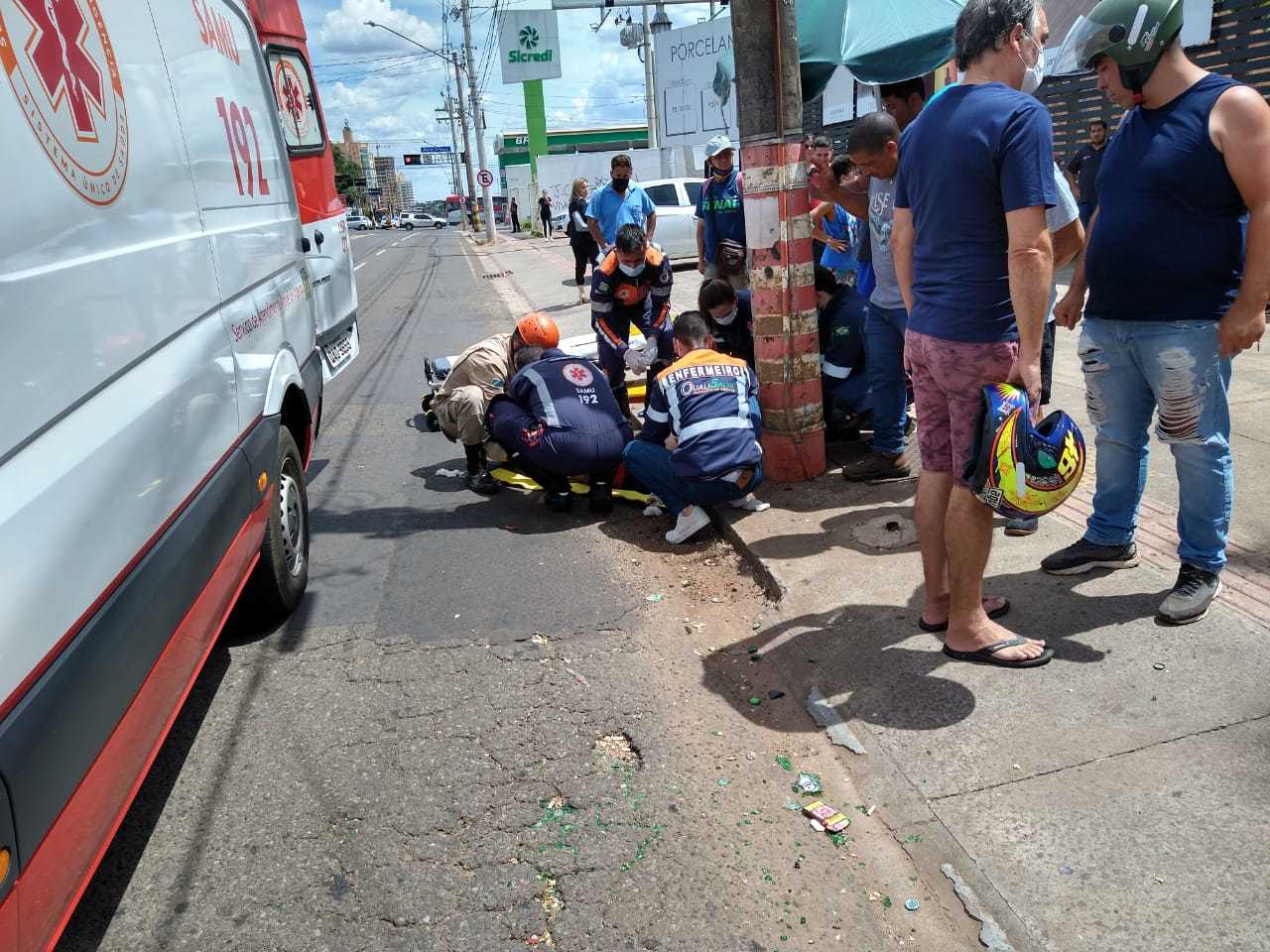 Motociclista sendo socorrido ao lado de poste atingido por ele após ser arremessado (Foto: Ana Paula Chuva)