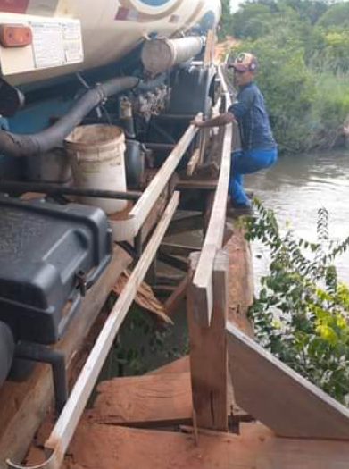 Morador se arrisca do lado de fora de caminhão parado sobre a ponte. (Foto: Direto das Ruas)